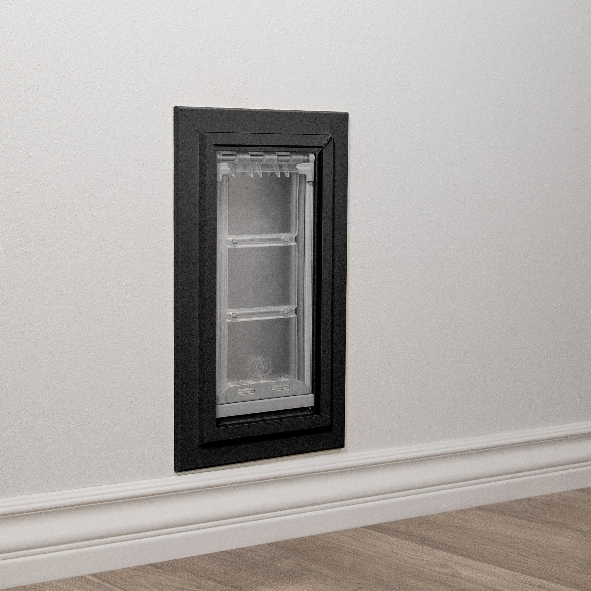 Installed black Endura Flap pet door for wall in an exterior wall. This demonstrates a practical solution for pet access with a durable wall mount dog door.