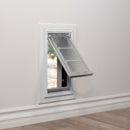 Installed view of a white Endura Flap dog door for walls, shown with the flap open. This illustrates how easily pets can use these through wall dog doors.