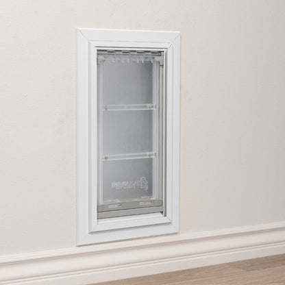 A white-framed "Endura Flap" pet door installed in a wall.