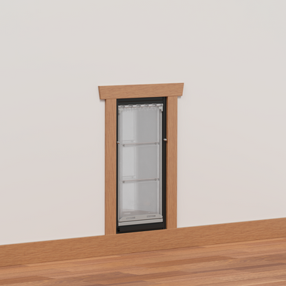 A dog door is installed in a white wall with a wooden frame.