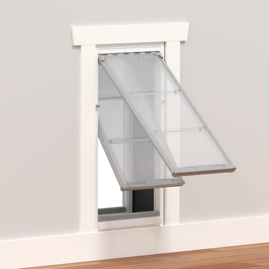 A pet door with clear flaps installed in a wall._Color_White