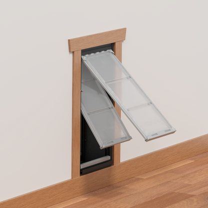 A pet door with two flaps is installed in a wall.