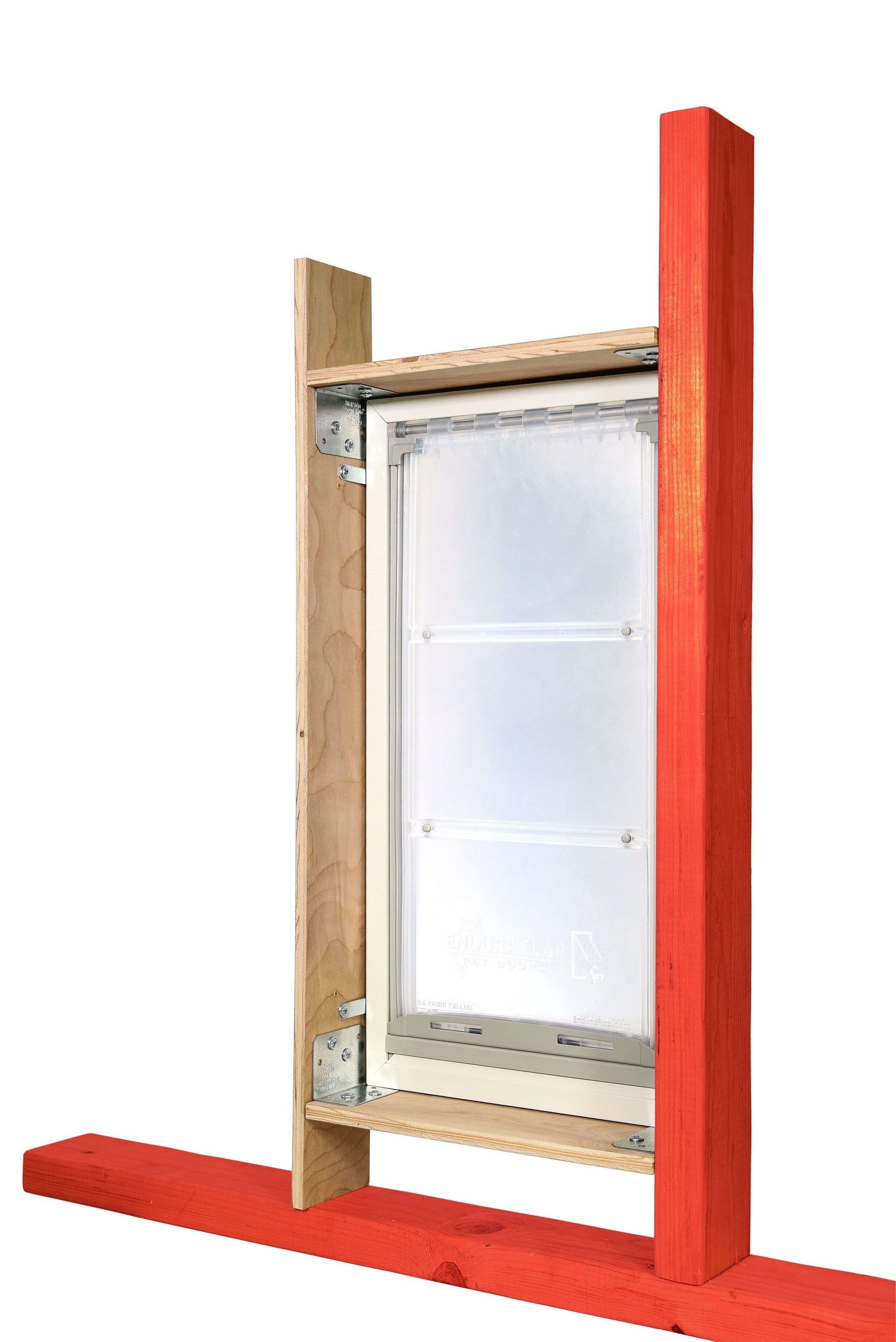 A framed Endura Flap pet door is mounted with support lumber.
