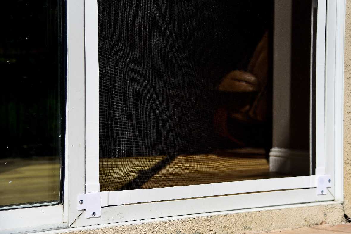 A close-up of a window with a white frame and a black screen.